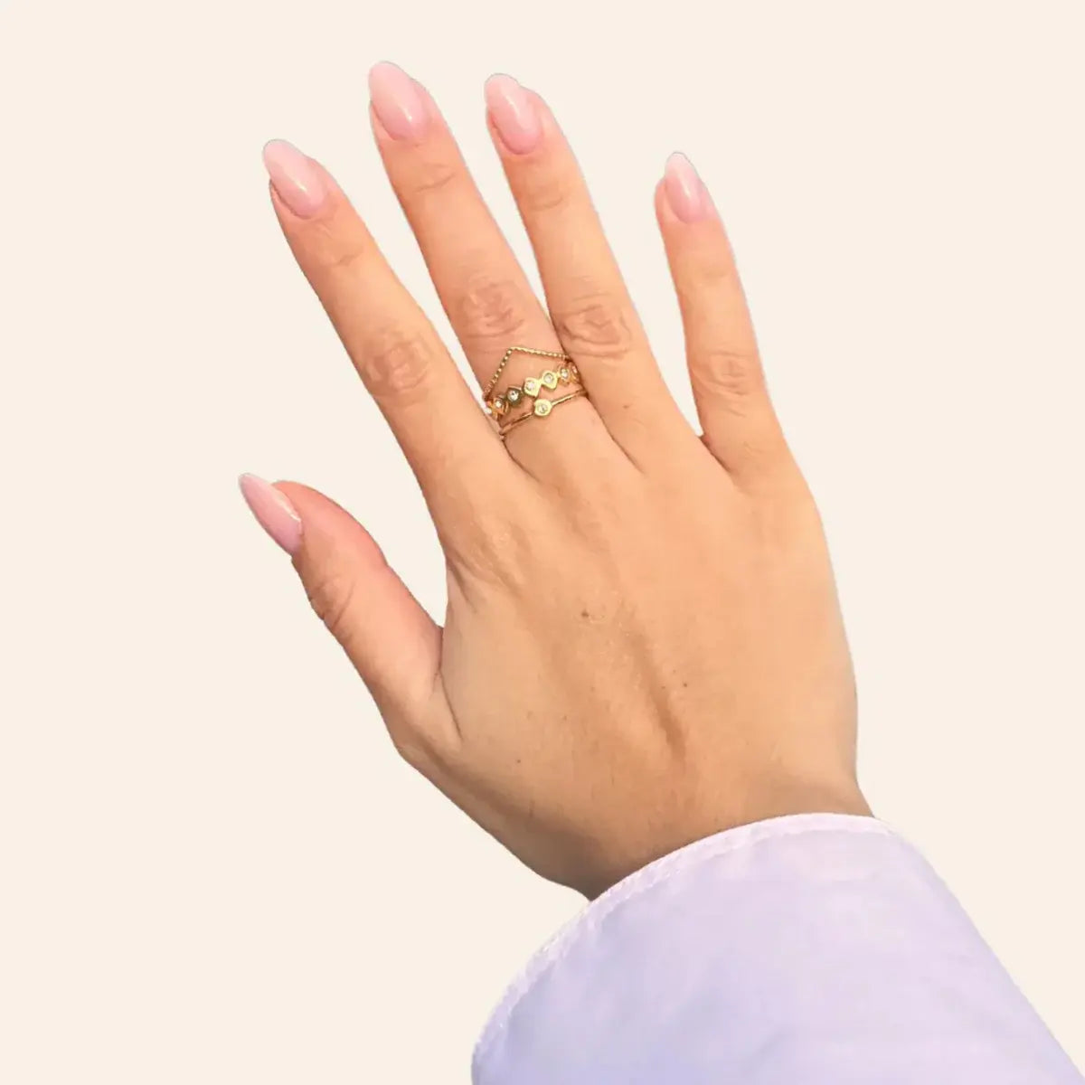 Main portant la bague Accra dorée en acier inoxydable, bijou tendance et raffiné.