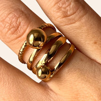 Zoom sur la bague Ankara dorée en acier inoxydable, détails brillants avec billes stylisées.