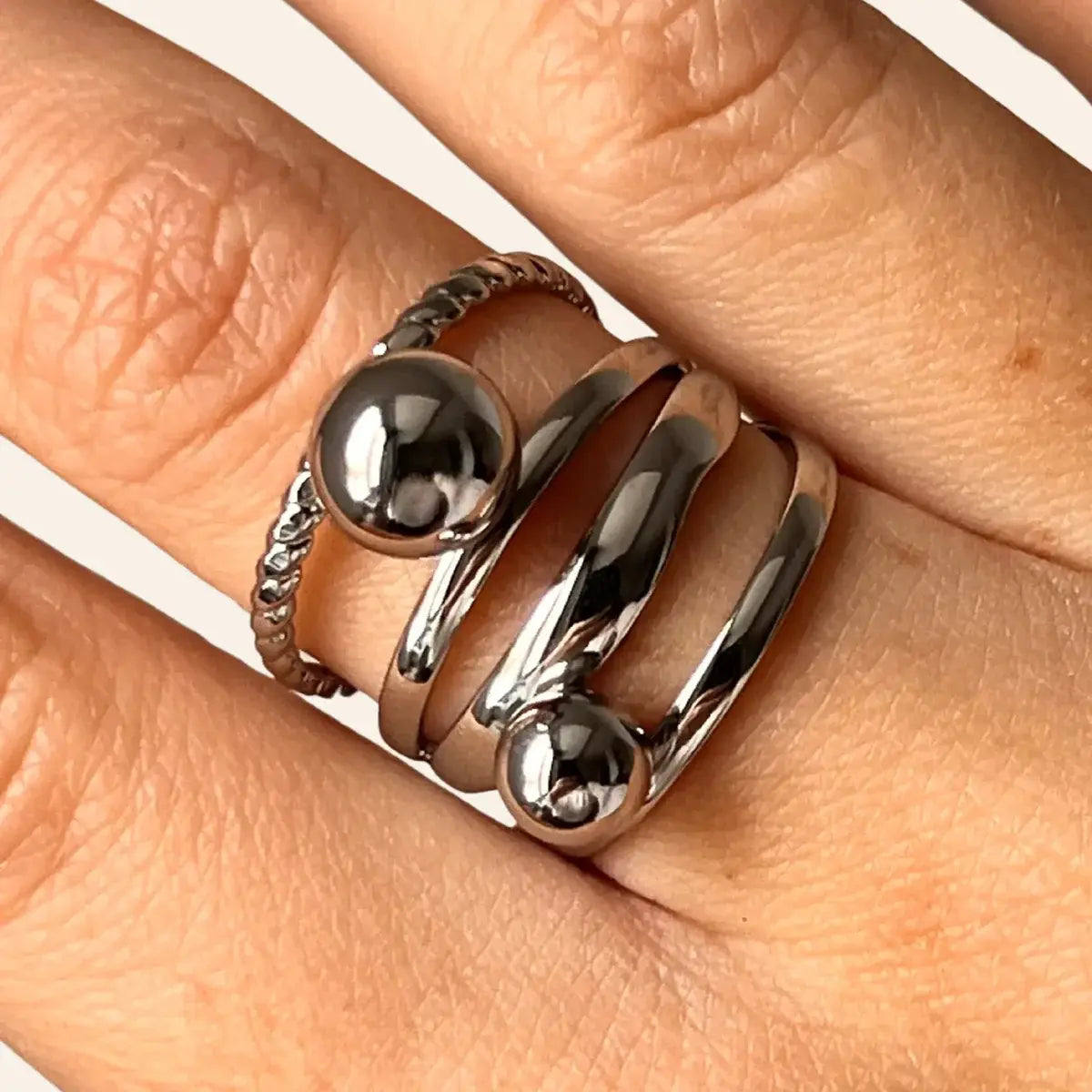 Gros plan de la bague Ankara argentée en acier inoxydable, anneaux larges et billes polies.