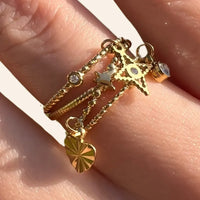 Zoom sur la bague Antalya en acier inoxydable doré, mettant en valeur les pendentifs raffinés et les oxydes de zirconium étincelants.