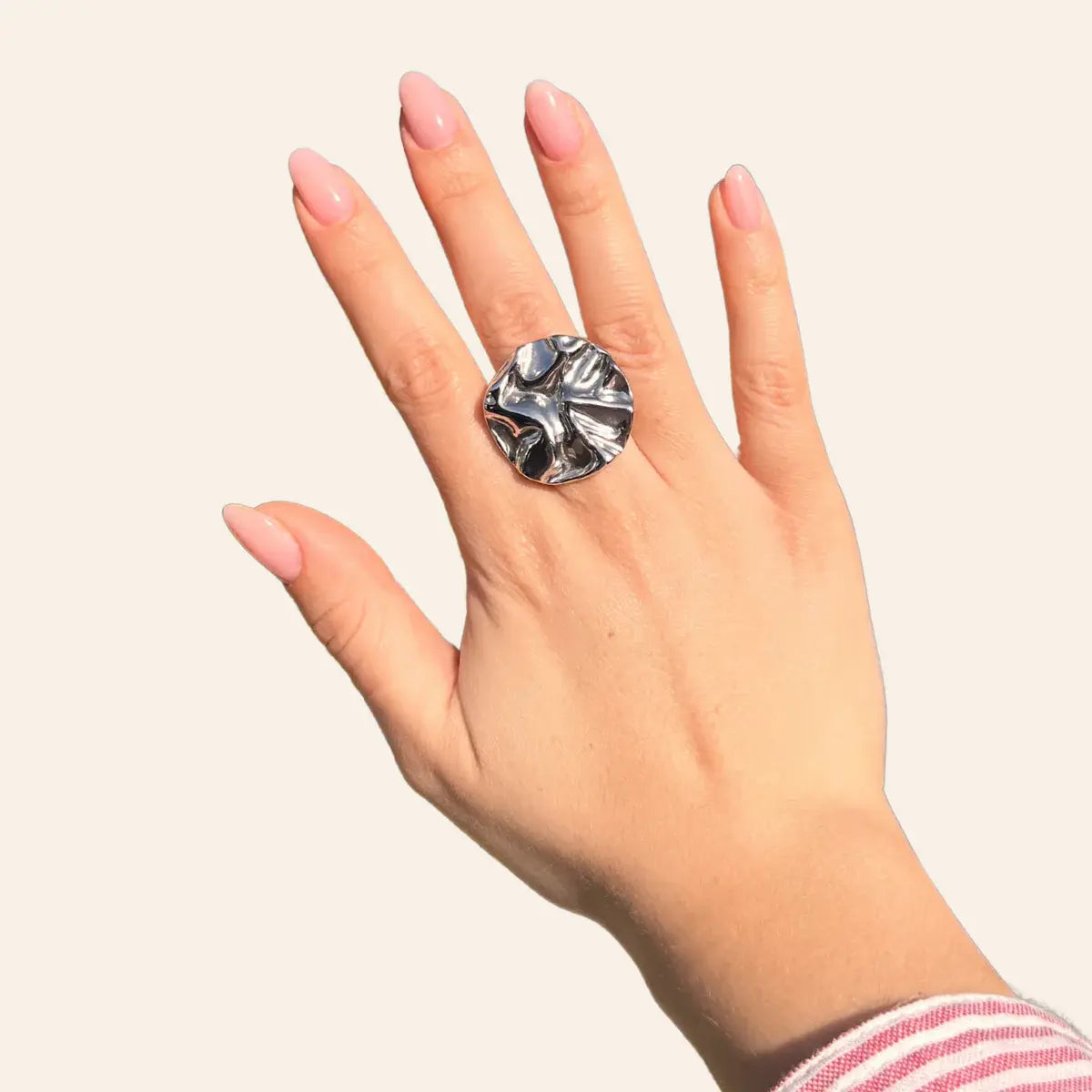 Bague Berlin en acier inoxydable argenté portée, design rond et moderne avec des courbes audacieuses, symbolisant l’élégance et l’innovation de Berlin.