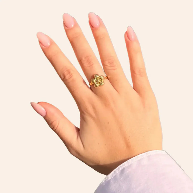 Bague Florence dorée portée, fleur en relief symbolisant la splendeur des jardins de la Renaissance et l'art intemporel de Florence, ajoutant une touche de raffinement à votre look.