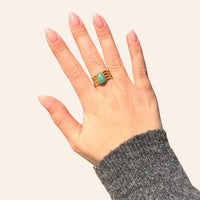 Main féminine portant la bague Jaipur dorée avec goutte bleue, bijou raffiné et coloré au design tendance.