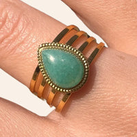 Zoom sur la bague Jaipur dorée en acier inoxydable, mettant en valeur la goutte bleue au centre et la finition brillante.