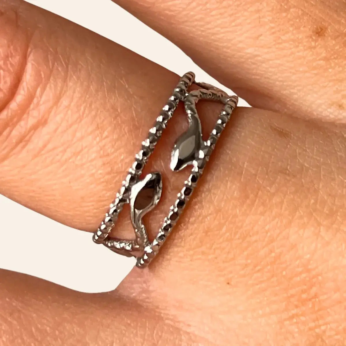 Gros plan sur la bague Jakarta argentée, détaillant les deux serpents entrelacés dans un design ajouré, inspiré de la ville dynamique et de sa culture fascinante.