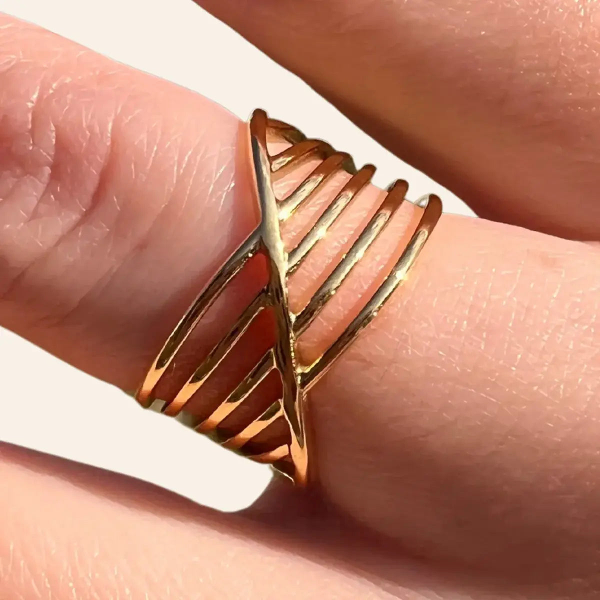 Gros plan sur la bague La Valette dorée en acier inoxydable, mettant en valeur son motif entrecroisé raffiné.