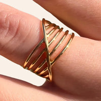 Gros plan sur la bague La Valette dorée en acier inoxydable, mettant en valeur son motif entrecroisé raffiné.