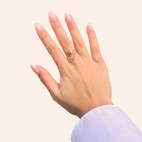 Bague Londres dorée portée, design unique avec étoile scintillante et chaîne suspendue, ajoutant une touche d’élégance urbaine et contemporaine à votre look.