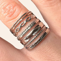 Gros plan sur la bague Rio en acier inoxydable argenté, soulignant les lignes ondulées et la finition brillante.