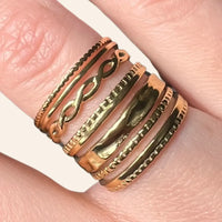 Zoom sur la bague Rio dorée en acier inoxydable, mettant en valeur les lignes ondulées et la texture lisse.