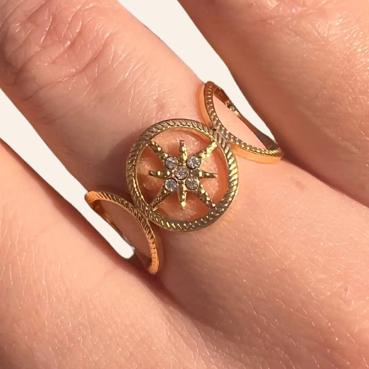 Gros plan sur la bague Sofia en acier inoxydable doré, détaillant l'étoile centrale ornée de strass étincelants.