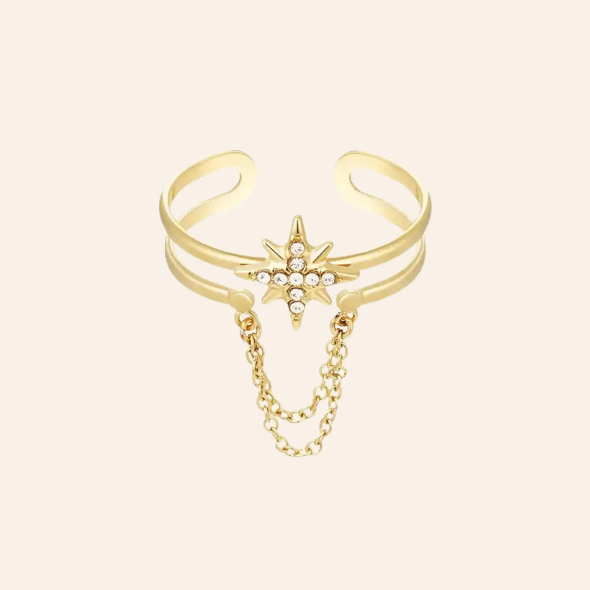 Bague Londres en acier inoxydable doré, étoile ornée de strass scintillants avec chaîne suspendue, capturant l'audace et le style avant-gardiste de Londres, présentée seule sur fond neutre.