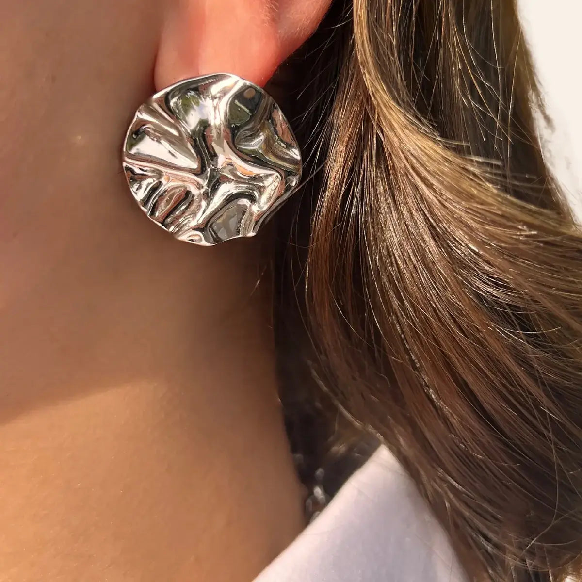 Boucles d’oreilles Berlin en acier inoxydable argenté portées, design moderne et artistique, ajoutant une touche d'élégance avant-gardiste à votre look.