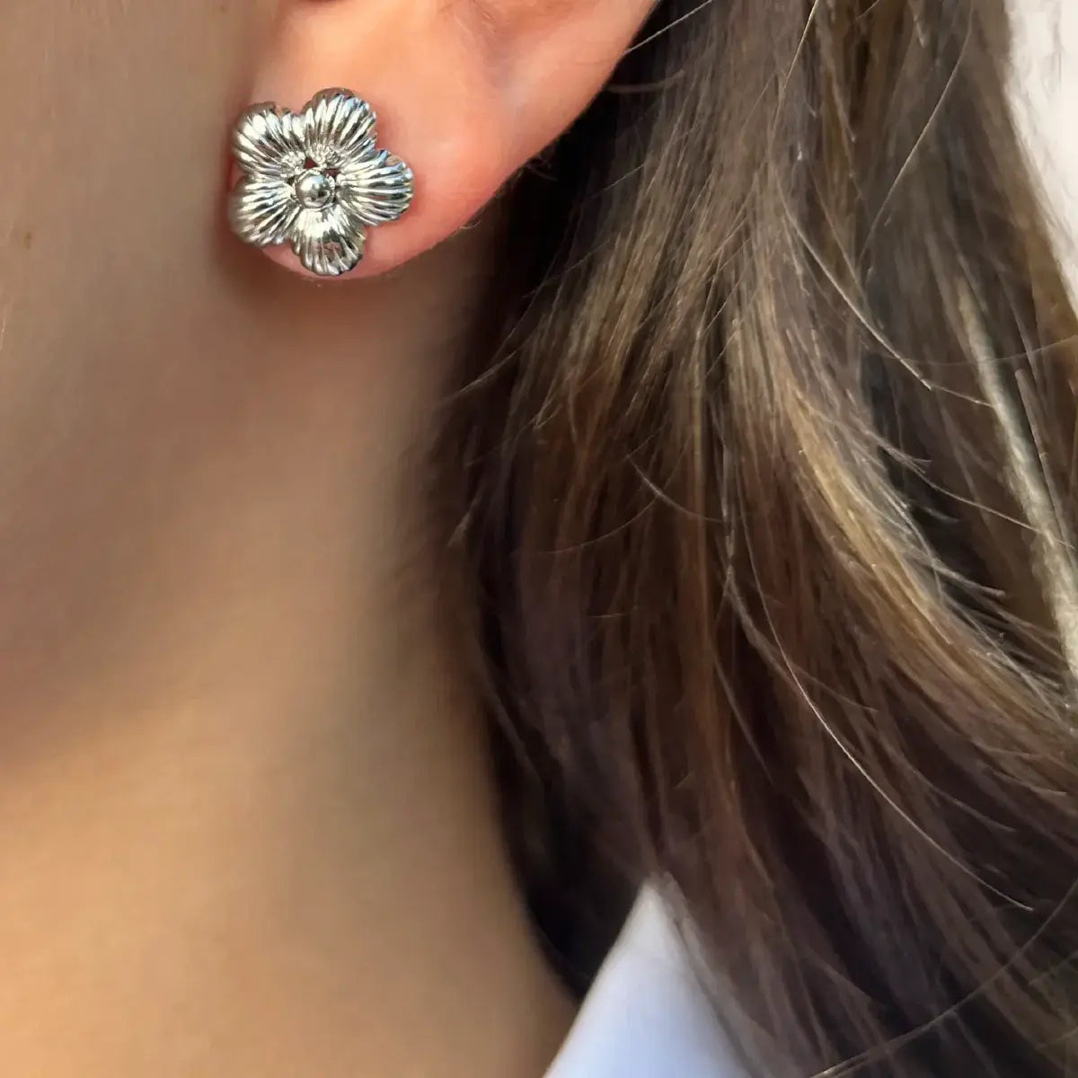 Boucles d’oreilles Florence en acier inoxydable argenté portées, symbole de grâce et de féminité, parfaites pour ajouter une touche sophistiquée à votre look.