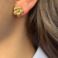 Boucles d’oreilles Florence dorées portées, design épuré et élégant mettant en valeur le visage avec un subtil motif floral.
