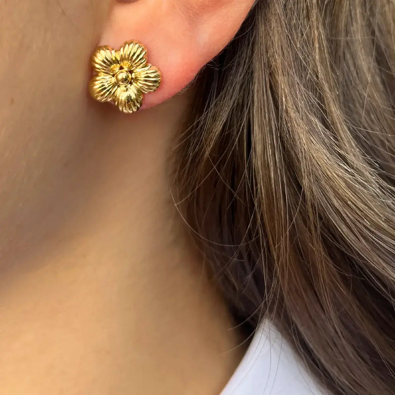 Boucles d’oreilles Florence dorées portées, design épuré et élégant mettant en valeur le visage avec un subtil motif floral.
