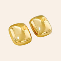 Boucles d’oreilles Manille carrées en acier inoxydable doré, design brillant et moderne, présentées seules sur fond neutre.