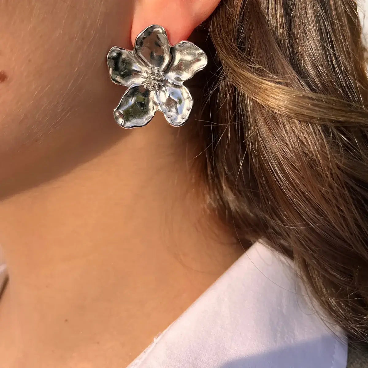 Boucles d’oreilles Nairobi en acier inoxydable argenté portées, design floral élégant, chaque pétale structuré travaillé avec soin, parfaites pour ajouter de la douceur et de la sophistication à votre style.