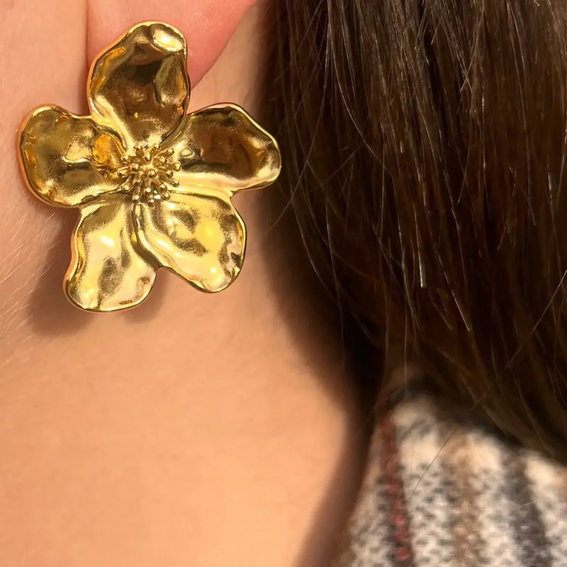 Boucles d’oreilles Nairobi dorées portées, design floral raffiné, structuré symbolisant la beauté vibrante et naturelle de Nairobi, ajoutant une touche élégante à votre look.