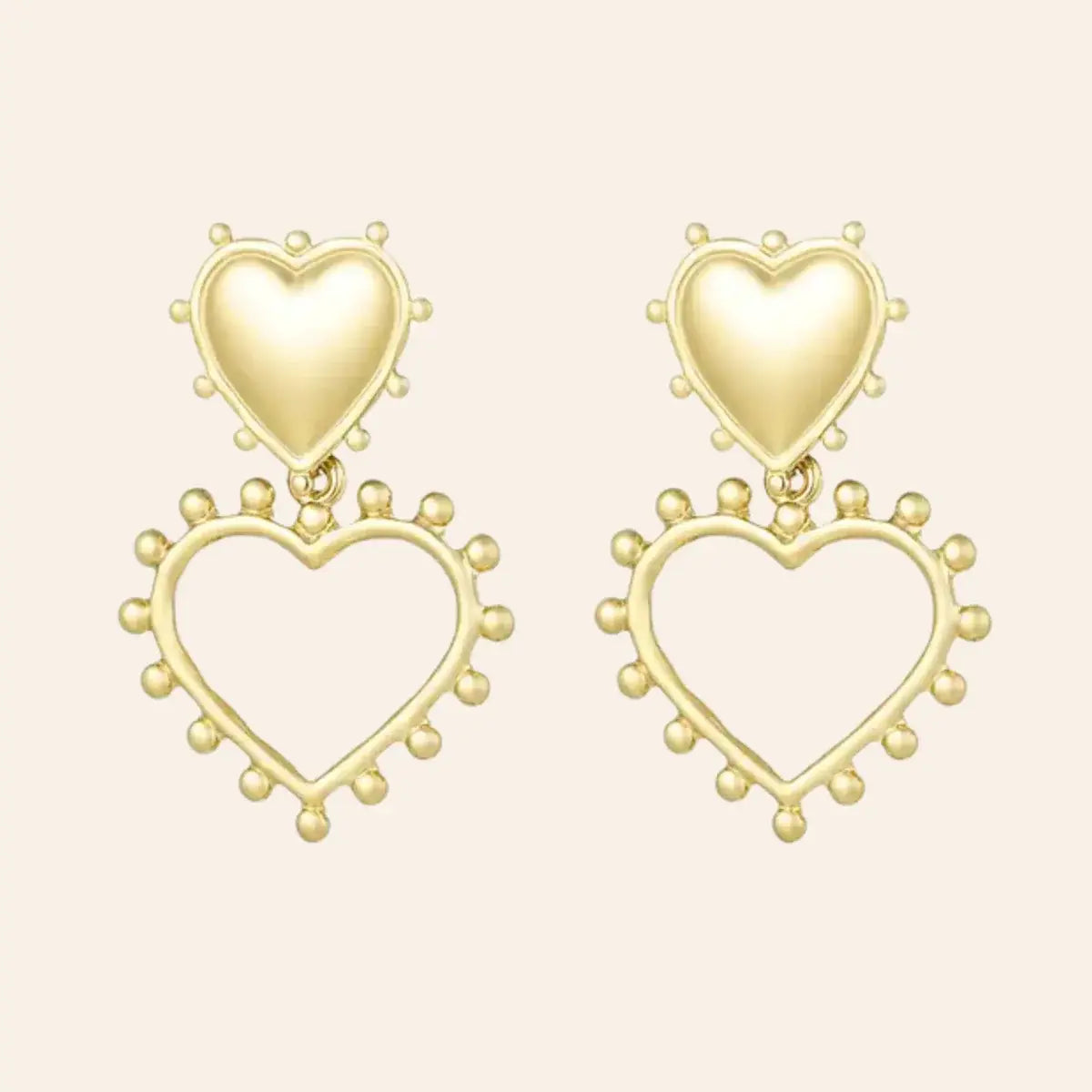 Boucles d’oreilles Paris en acier inoxydable doré, design élégant avec un cœur plein et un cœur ouvert en dessous, ornés de petites perles délicates, présenté seul sur fond neutre.