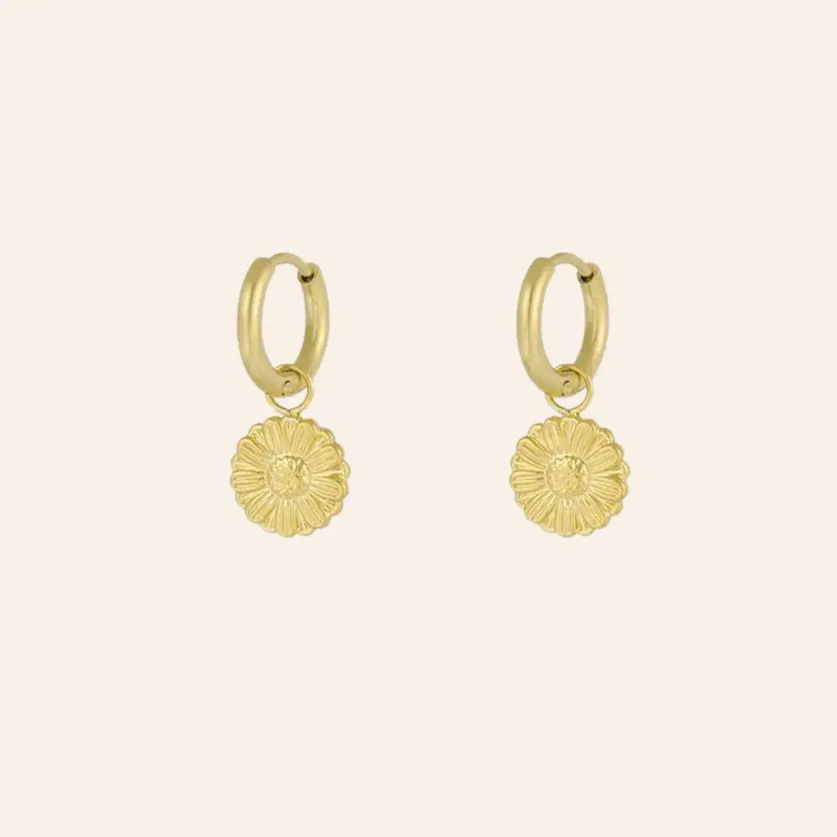 Boucles d’oreilles Pretoria en acier inoxydable doré, petite fleur suspendue, design délicat et élégant, présenté seul sur fond neutre.