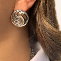 Boucles d’oreilles Séoul en acier inoxydable argenté portées, design circulaire fluide, évoquant la modernité et l'harmonie de Séoul.
