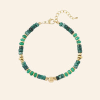 Bracelet Amsterdam en acier inoxydable doré, perles vertes et dorées délicates, design bohème et élégant, présenté seul sur fond neutre.