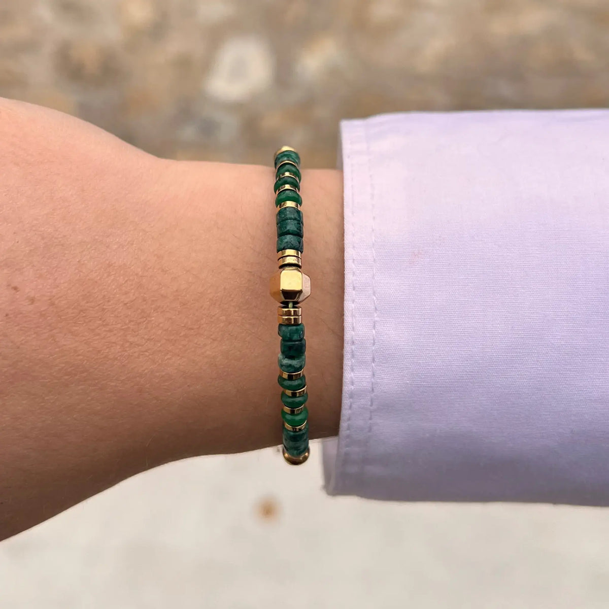 Bracelet Amsterdam doré porté, perles vertes et dorées ajoutant une touche de sophistication et d'originalité à votre look.