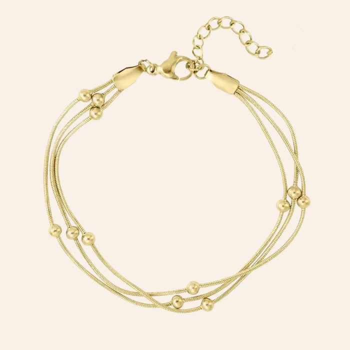 Bracelet Barcelone en acier inoxydable doré, fines chaînes entrelacées avec petites perles délicates, présenté seul sur fond neutre.