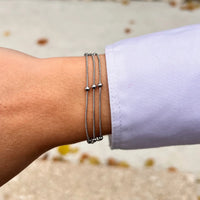Bracelet Barcelone en acier inoxydable argenté porté, mélange subtil de chaînes entrelacées et perles pour un style raffiné.