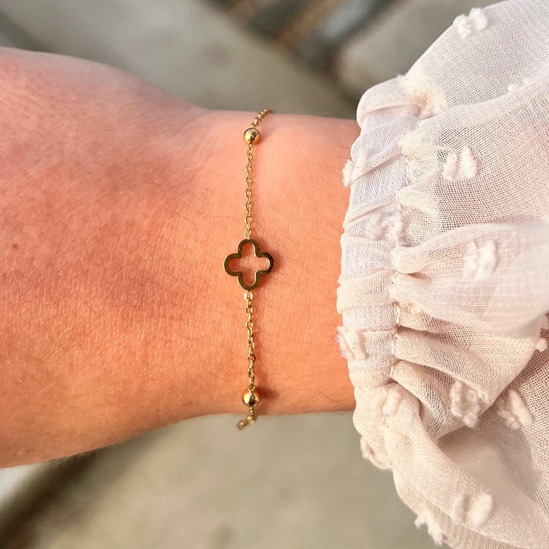 Bracelet Dublin doré porté, bijou délicat avec trèfles et boules espacées, ajoutant une touche subtile et élégante à votre poignet.