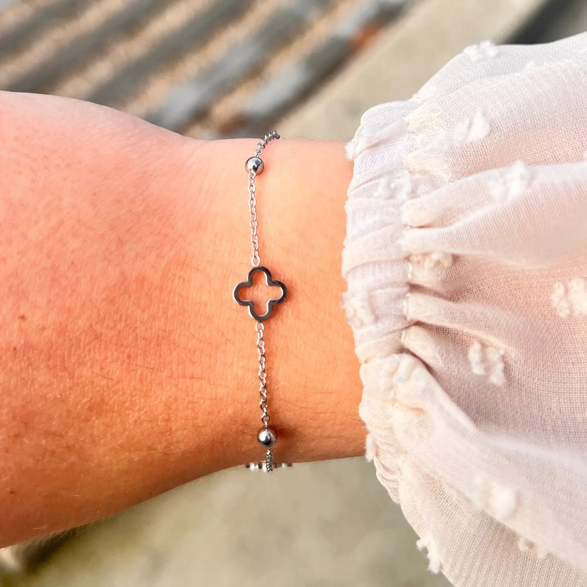 Bracelet Dublin en acier inoxydable argenté porté, avec ses trèfles et boules espacées, parfait pour un look léger et raffiné.