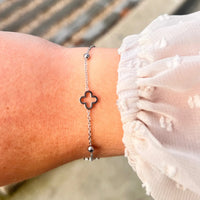 Bracelet Dublin en acier inoxydable argenté porté, avec ses trèfles et boules espacées, parfait pour un look léger et raffiné.
