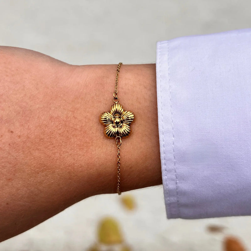 Bracelet Florence doré porté, fleur délicate apportant une touche de féminité et de raffinement à votre poignet, ajoutant de la grâce à chaque mouvement.