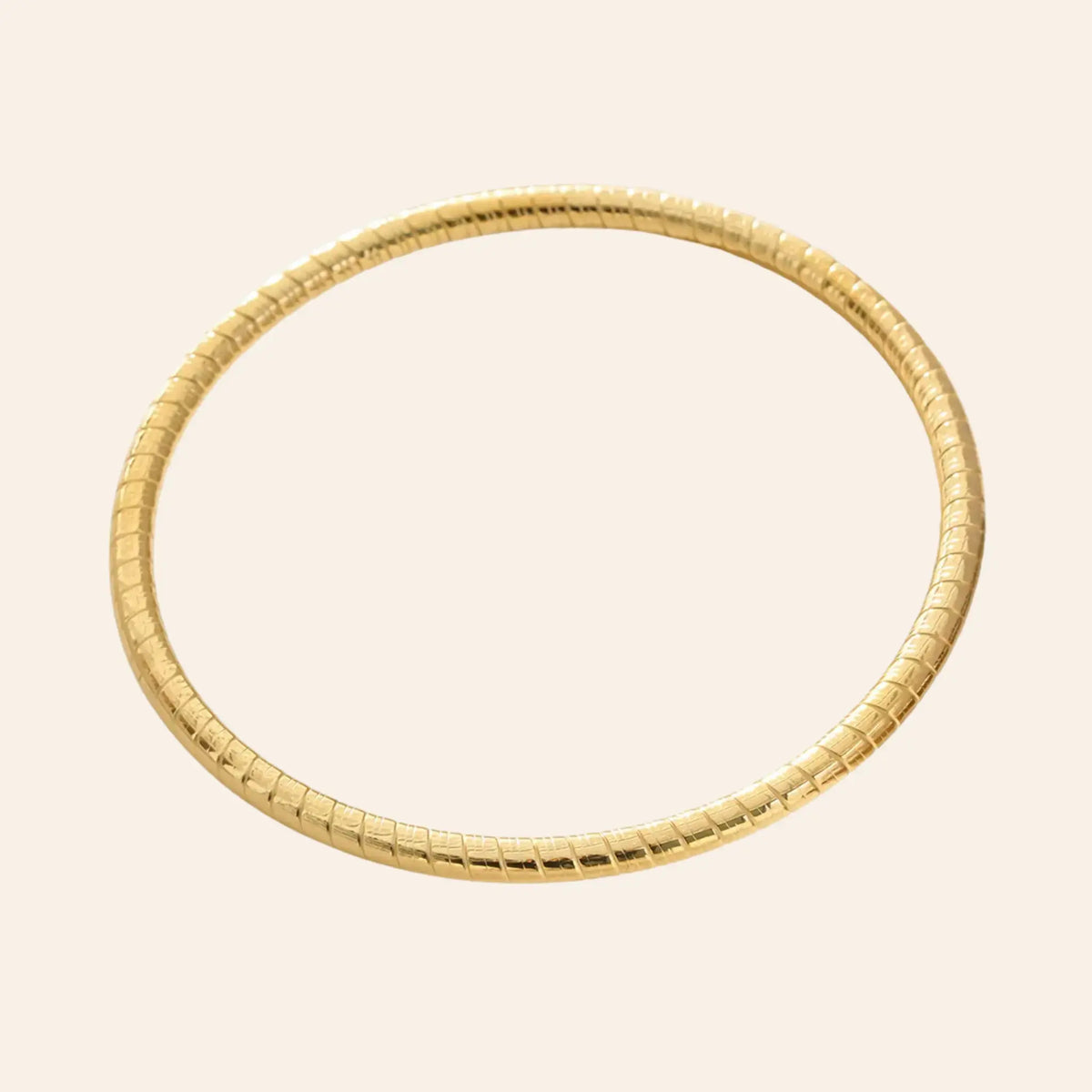Bracelet Jonc Quito en acier inoxydable doré, design simple avec petits traits gravés, présenté seul sur fond neutre.