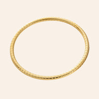 Bracelet Jonc Quito en acier inoxydable doré, design simple avec petits traits gravés, présenté seul sur fond neutre.