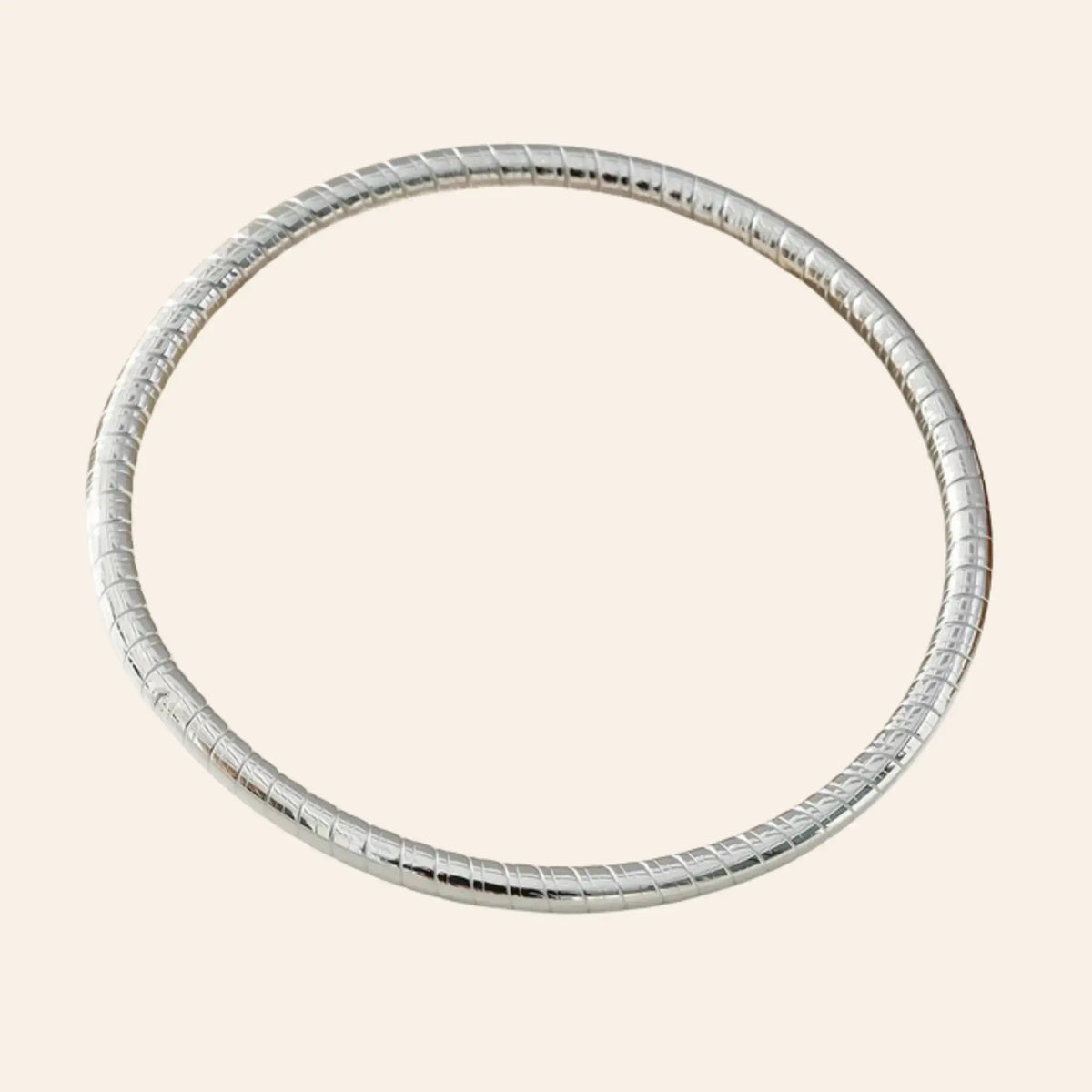 Bracelet Jonc Quito en acier inoxydable argenté, bijou minimaliste avec des détails subtils de petits traits.