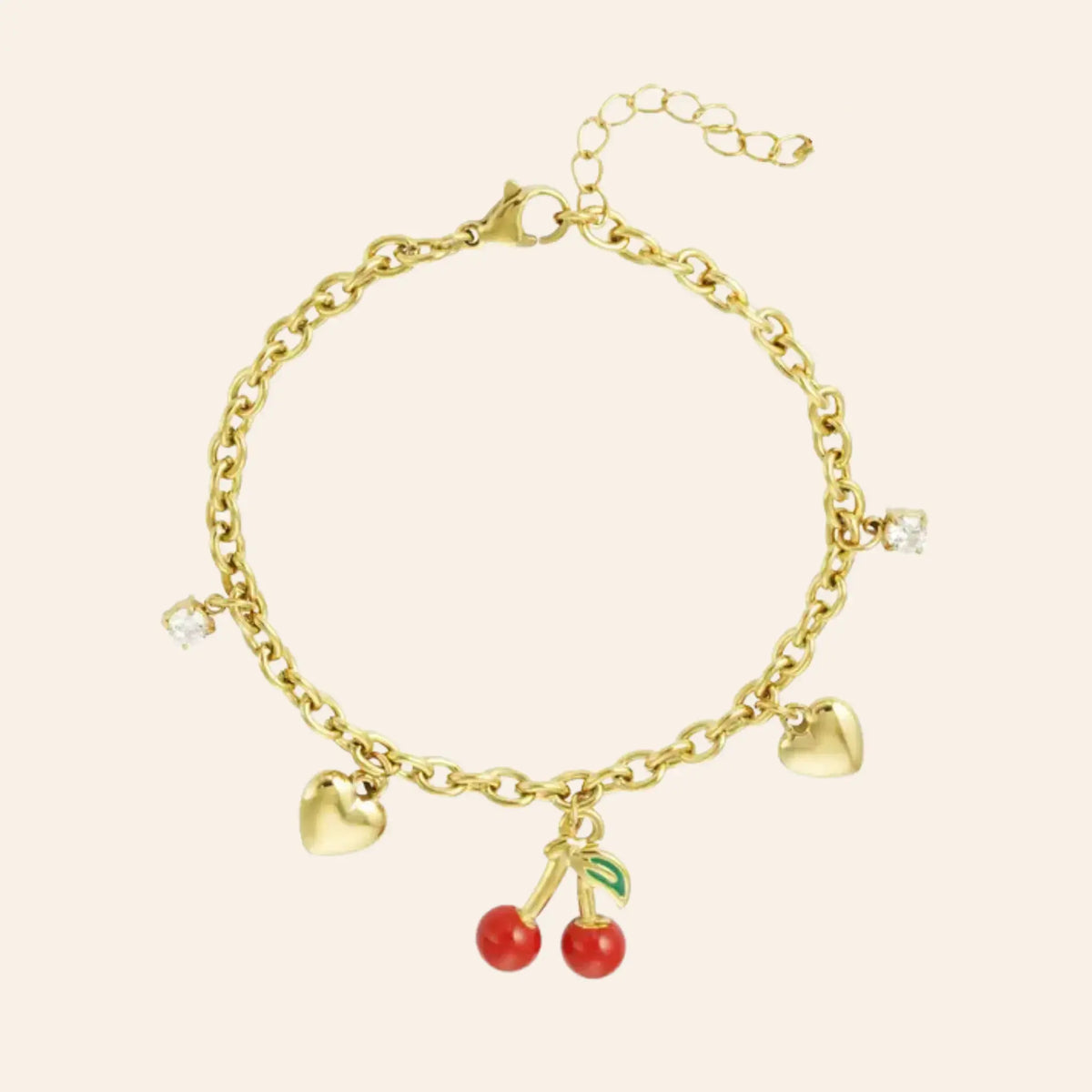 Bracelet Lisbonne en acier inoxydable doré, charm délicat avec deux petits cœurs et pendentif cerise rouge vif, présenté seul sur fond neutre.