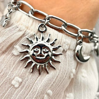Bracelet Madrid en acier inoxydable argenté porté, éléments célestes et cœur pendants, ajoutant une touche de lumière et de romantisme à votre poignet.