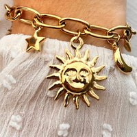 Bracelet Madrid doré porté, charms représentant les éléments célestes et le cœur, symbolisant la lumière et la passion de Madrid.