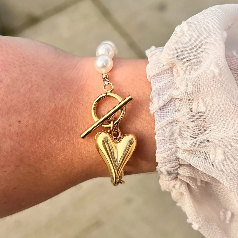 Bracelet Prague doré porté, combinaison de perles et chaînes modernes avec charm cœur, ajoutant une touche de romance à votre poignet.