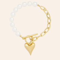Bracelet Prague en acier inoxydable doré, moitié perles délicates et moitié chaînes, orné d'un charm cœur, présenté seul sur fond neutre.