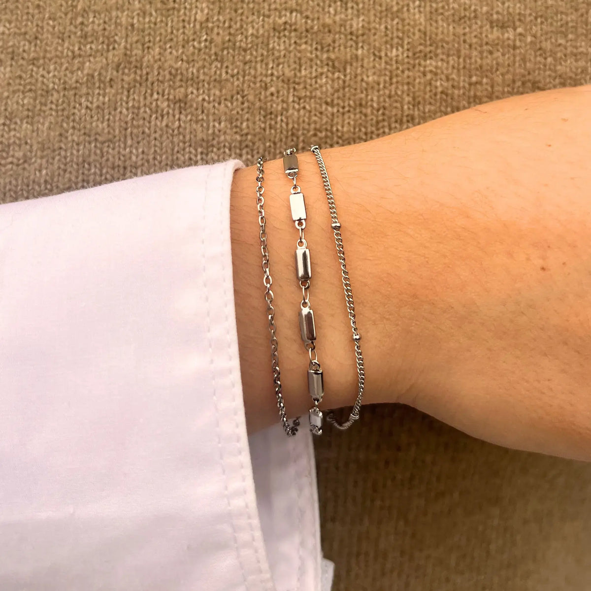 Bracelet Santiago en acier inoxydable argenté porté, ajoutant une touche d'élégance urbaine avec ses chaînes et maillons délicats.