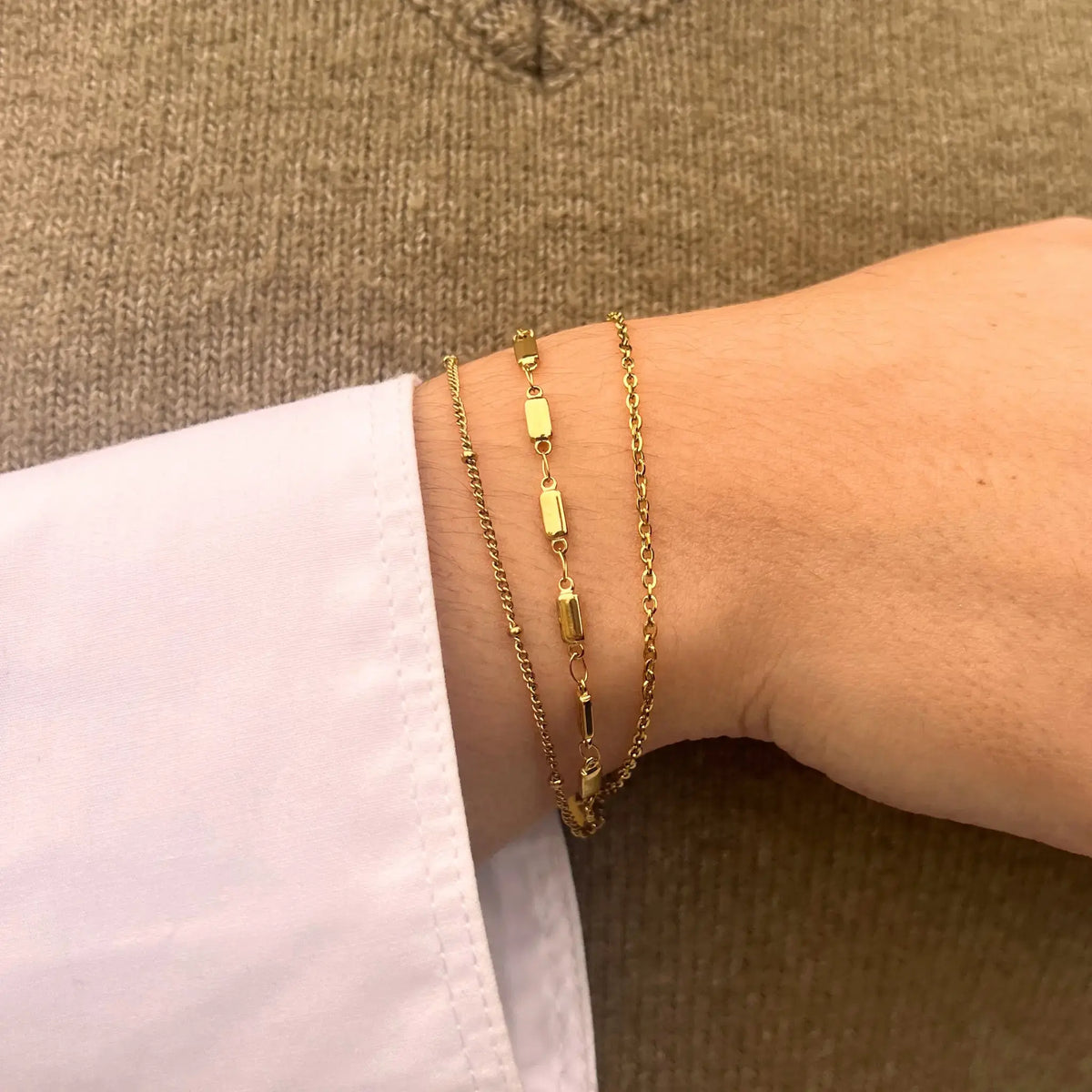 Bracelet Santiago doré porté, bijou élégant et raffiné avec chaînes entrelacées et maillons délicats, capturant l'énergie vibrante de Santiago.