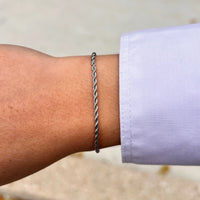 Bracelet Venise en acier inoxydable argenté porté, design intemporel avec chaîne torsadée qui s’adapte à toutes les tenues.