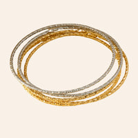 Lot de 5 bracelets joncs Carthagène en acier inoxydable, composé de 3 joncs dorés et 2 argentés au design finement structuré, présenté seul sur fond neutre.