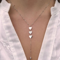 Collier Buenos Aires en acier inoxydable argenté porté, cœurs suspendus capturant l'intensité et la sophistication de Buenos Aires.