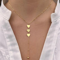 Collier Buenos Aires doré porté, cœurs suspendus symbolisant l'amour et l'élégance, ajoutant une touche passionnée à votre look.