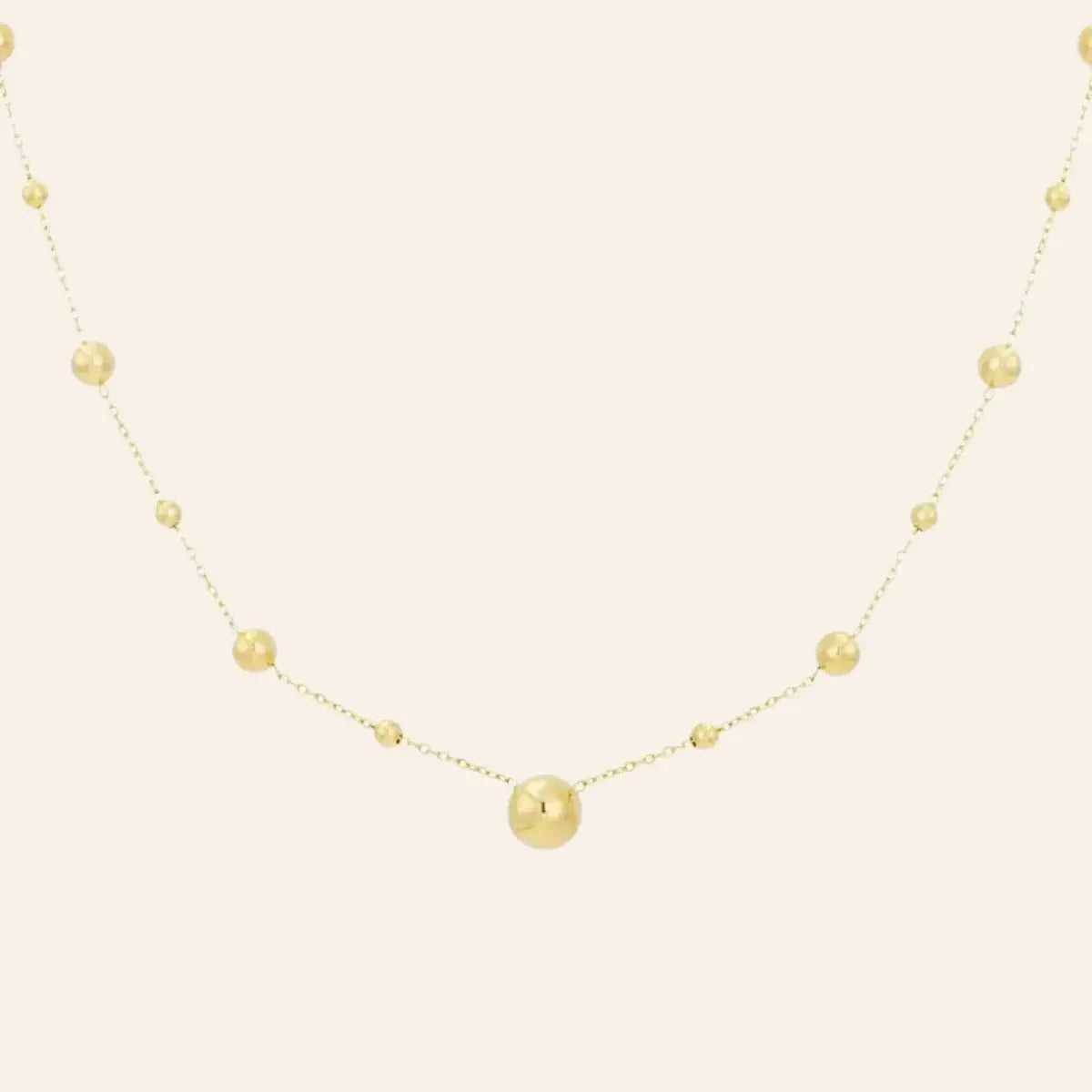 Collier Kyoto en acier inoxydable doré, chaîne délicate ornée de sphères espacées, présenté seul sur fond neutre.
