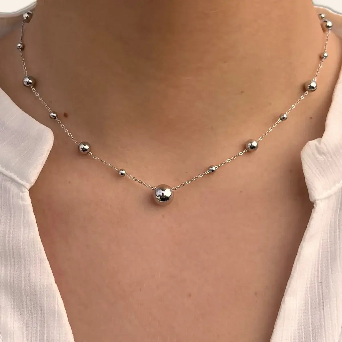Collier Kyoto en acier inoxydable argenté porté, mettant en valeur l’espacement subtil des sphères et le design élégant.